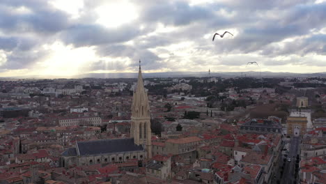 Möwe-Jagt-Eine-Drohne,-Luftaufnahme-Des-Sonnenuntergangs-Der-Saint-Anne-Kirche-In-Montpellier